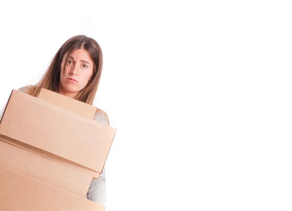 Worried girl holding a weighty cardboard boxes — Stock Photo, Image