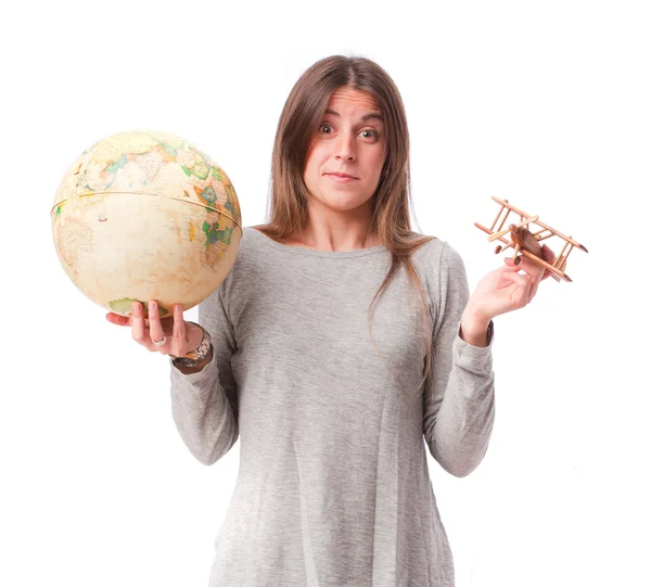 女孩抱着世界地球仪和木飞机 — 图库照片