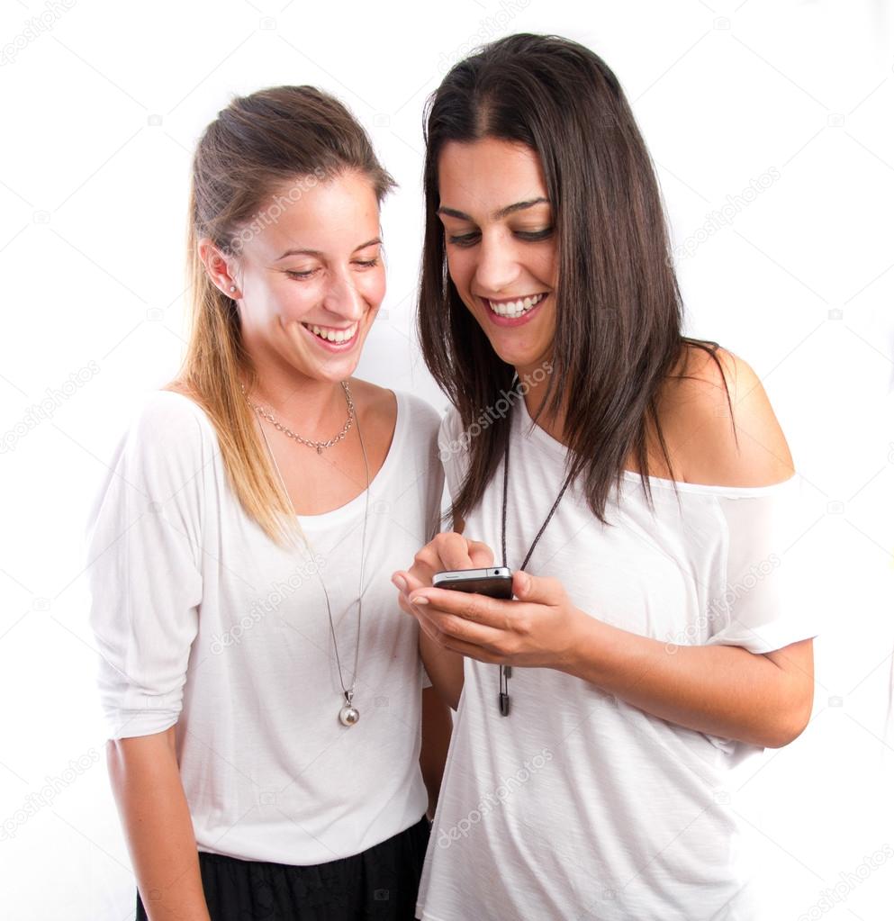 Two happy girls with a mobile