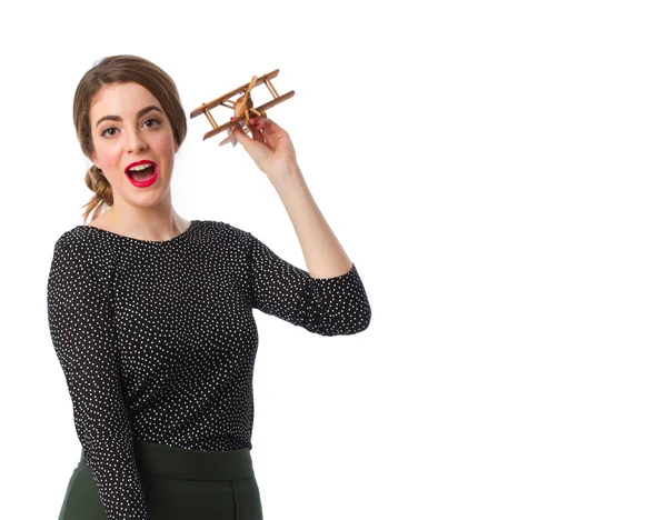 Chica joven lanzando un avión de madera —  Fotos de Stock