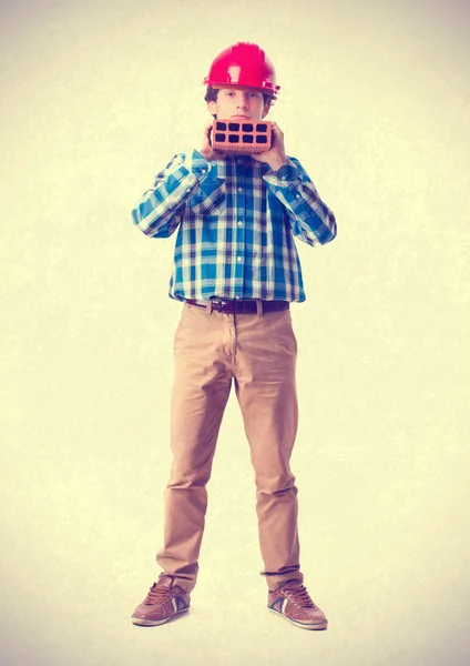 Teenager with work helmet holding a brick. isolated — Stock Photo, Image