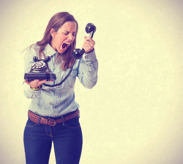 Young woman shouting and holding a telephone — Stock Photo, Image