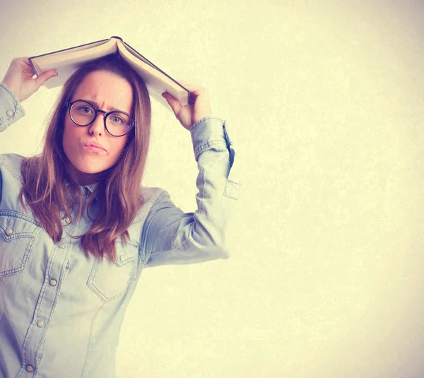 Giovane ragazza con libro sulla testa — Foto Stock