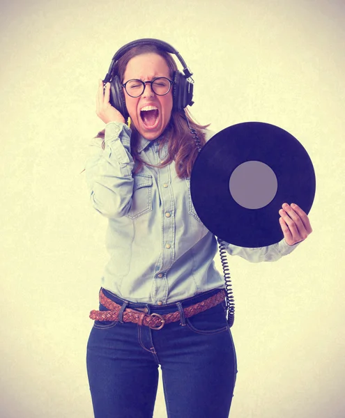 Mujer joven con auriculares sosteniendo un vinilo — Foto de Stock