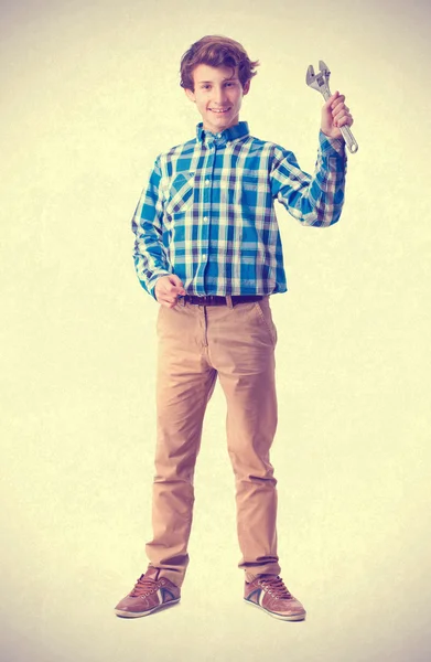 Teenager holding an ajustable wrench — Stock Photo, Image