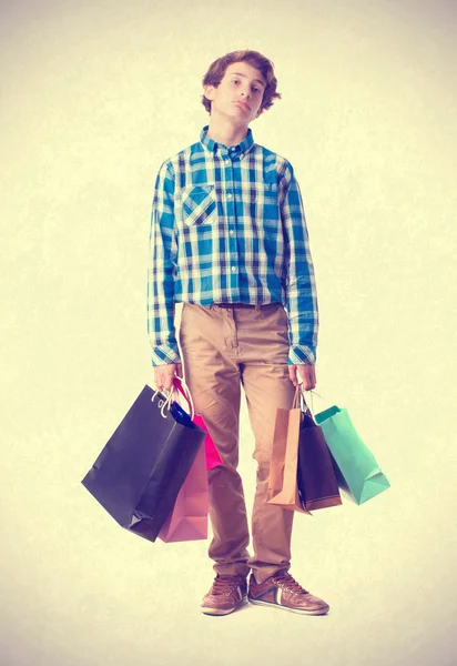 Adolescente aburrido sosteniendo bolsas de compras. aislado — Foto de Stock