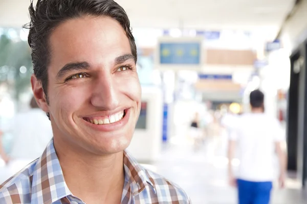 Homem bonito rindo em um centro comercial — Fotografia de Stock