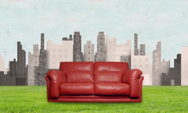 Czerwona skórzana kanapa na tle miasta — Zdjęcie stockowe