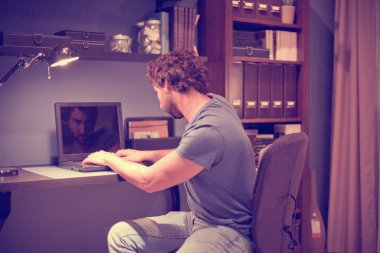 Dizüstü bilgisayarda çalışan adam