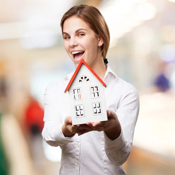 Blonde vrouw met een klein huis — Stockfoto