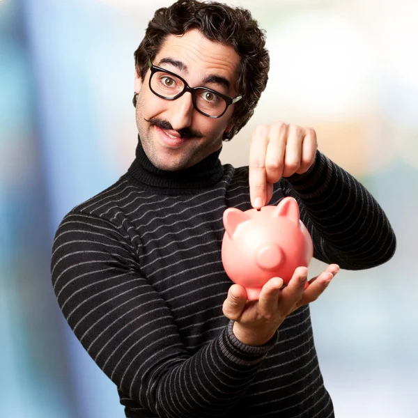 Homem pedante com um banco porquinho — Fotografia de Stock