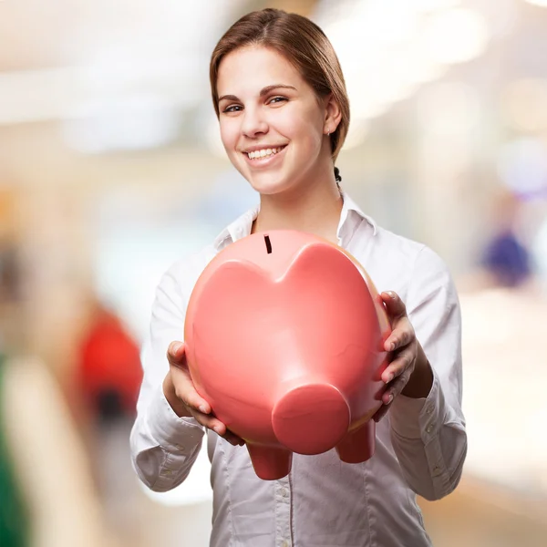 Blond woman with a piggy bank — Stock Photo, Image