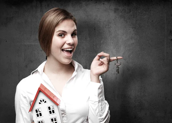 Blonde vrouw met een klein huis en sleutels — Stockfoto