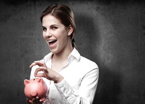 Blond woman with a piggy bank — Stock Photo, Image