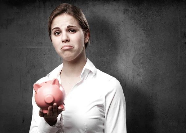Blonde Frau mit Sparschwein. Trauriges Zeichen — Stockbild Blonde Frau mit Sparschwein. Trauriges Zeichen — Stockfoto