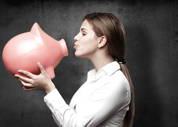 Blond woman with a piggy bank — Stock Photo, Image