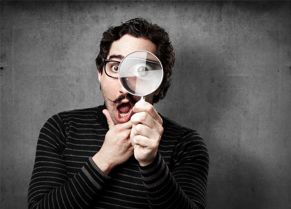 Pedantic man with a magnifier surprised Royalty Free Stock Images