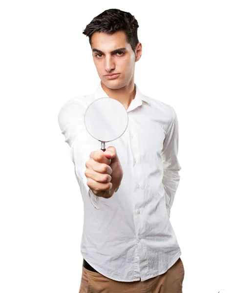 Surprised young man with magnifying glass — Stock Photo, Image