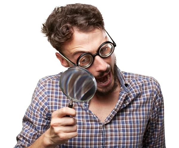 Crazy young man with magnifying glass — Stock Photo, Image