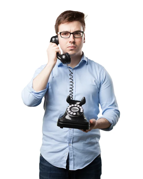 Confused young man with telephone — Stock Photo, Image