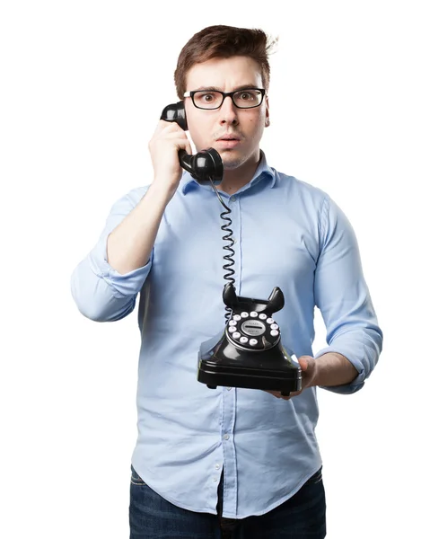 Verwirrter junger Mann mit Telefon — Stockfoto