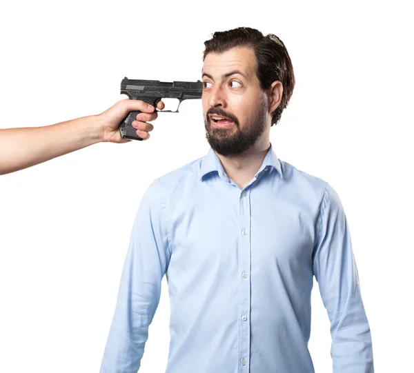 Испуганный молодой человек с пистолетом — стоковое фото