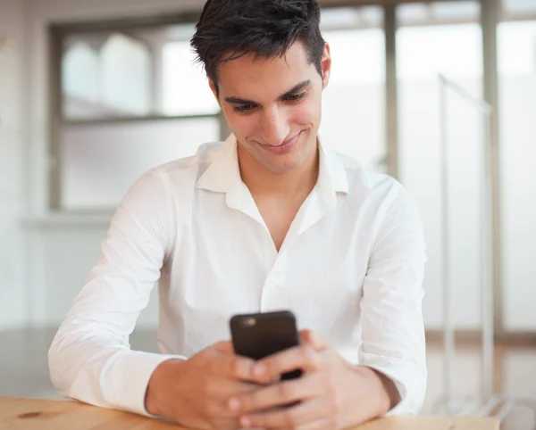Onnellinen nuori mies matkapuhelimen kanssa — kuvapankkivalokuva