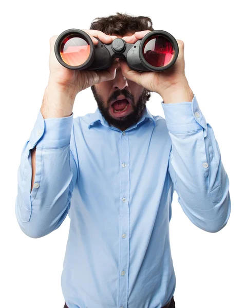 Surprised young man with binoculars — Stock Photo, Image