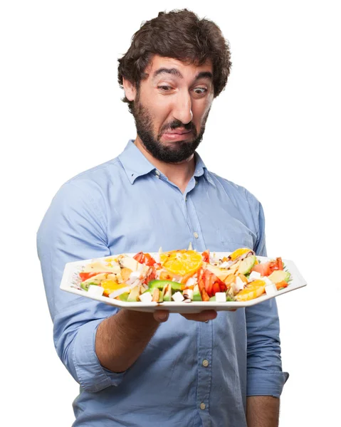Junger Mann erbricht Schild mit Salat — Stockfoto