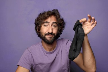 Kirli çorabı olan genç, sakallı bir adam.
