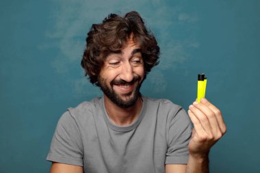 Genç, sakallı ve çakmaklı bir adam.