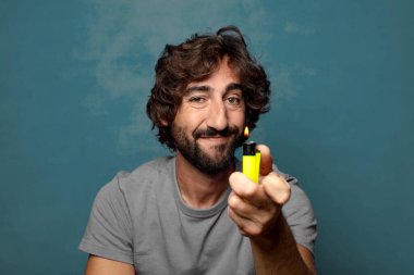 Genç, sakallı ve çakmaklı bir adam.