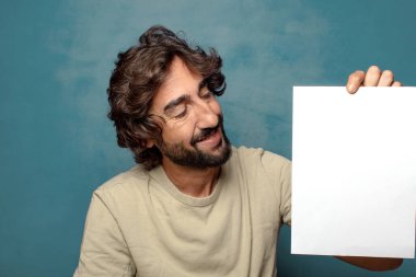 Genç, sakallı, elinde kağıt olan bir adam.