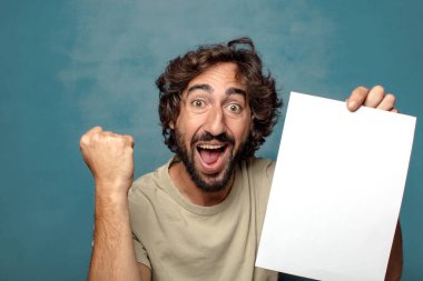 Genç, sakallı, elinde kağıt olan bir adam.