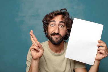 Genç, sakallı, elinde kağıt olan bir adam.