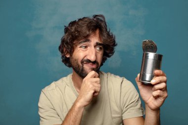 Genç, sakallı, çelik tenekeli adam.