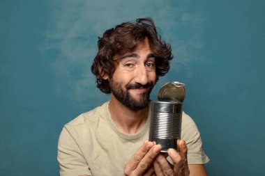 Genç, sakallı, çelik tenekeli adam.