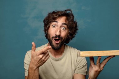 Boş tahta kesim masası olan genç, sakallı bir adam.