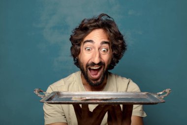 Gümüş tepsisi olan genç, sakallı bir adam.