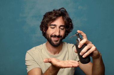 Sabun makinesi olan genç, sakallı bir adam.