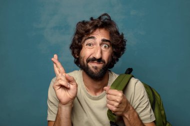 Çantası olan genç, sakallı bir adam.