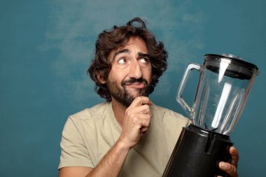 Genç, sakallı, blender makineli bir adam.