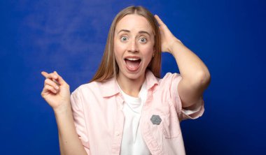 Gülüyor, mutlu, pozitif ve şaşırmış görünüyor. Yan fotokopi alanını işaret eden harika bir fikri fark ediyor.