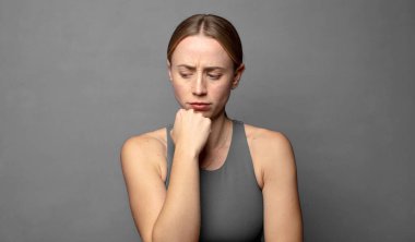 Ciddi, düşünceli ve endişeli hissediyorum. Elleri çenesine bastırılmış bir şekilde yan yan bakıyor. fitness konsepti