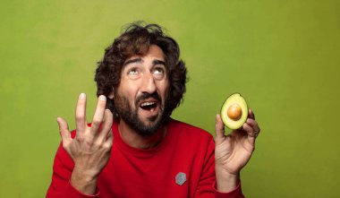 Avokadosu olan sakallı genç bir adam.