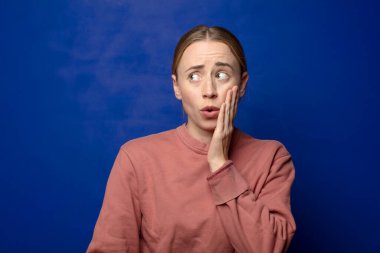 Sarışın kadın şoke olmuş ve ağzı açık halde yüz yüze inanamamaktan şaşkına dönmüş durumda.