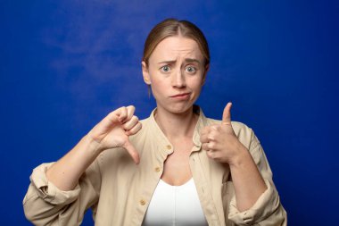 Sarışın kadın kafası karışık, bilgisiz ve kararsız hissediyor, iyi ve kötü seçenekleri ya da seçenekleri tartıyor.