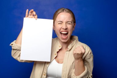 Genç, sarışın bir kadın elinde bir kağıt tutuyordu.