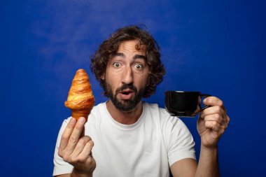 Genç, sakallı bir adam ve Fransız kahvaltısı.