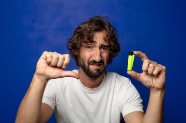 Genç, sakallı ve çakmaklı bir adam.